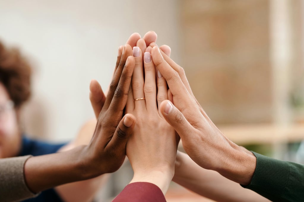 An image of a group of church members putting their hands together during a Catholic church fundraising event