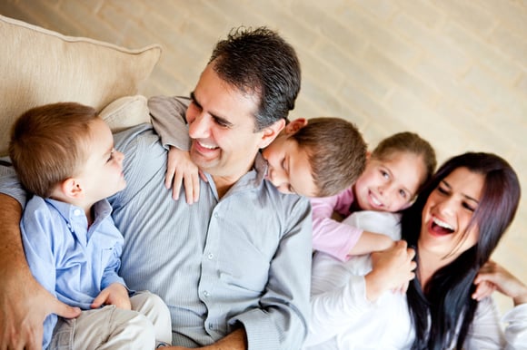 Image of Beautiful family having fun at home sitting on the sofa