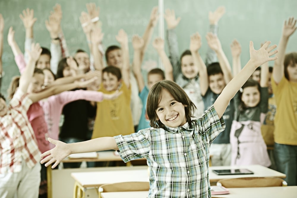 Cheerful group of kids at school room having education activity