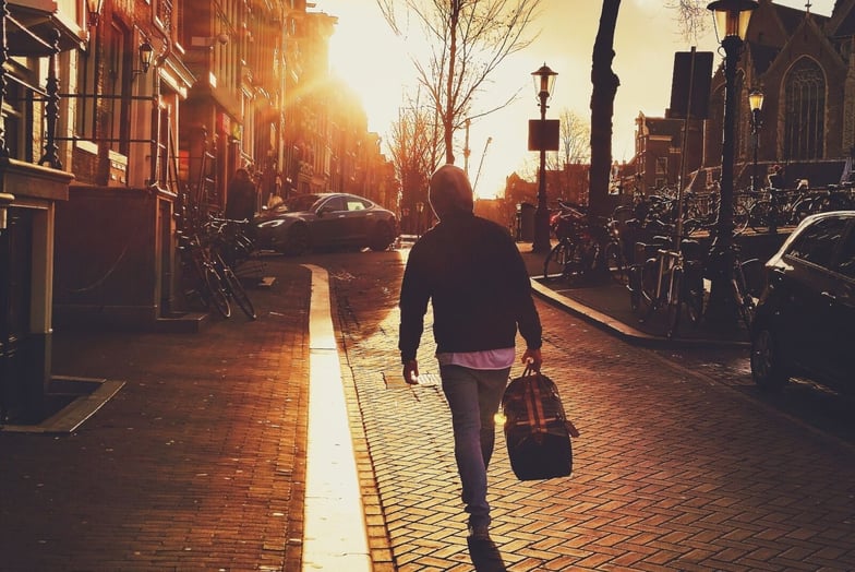 Church Member leaving at sunset carrying bag