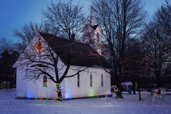 Church in snowy environment with Christmas decorations around it