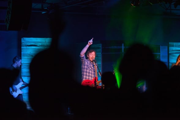 Church worship leader singing along with audience during worship service