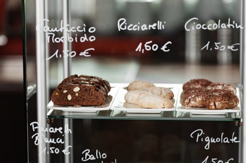 Closeup of cake and biscuits in display cabinet at coffee shop