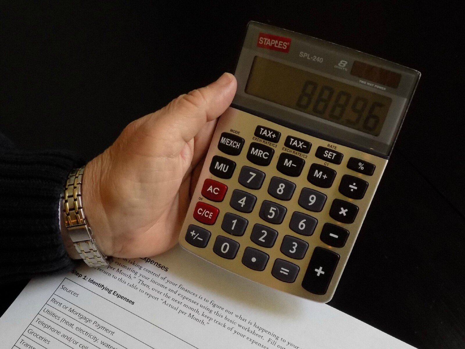 Elementary School Finance Worker with Calculator in Hand Doing a Budget