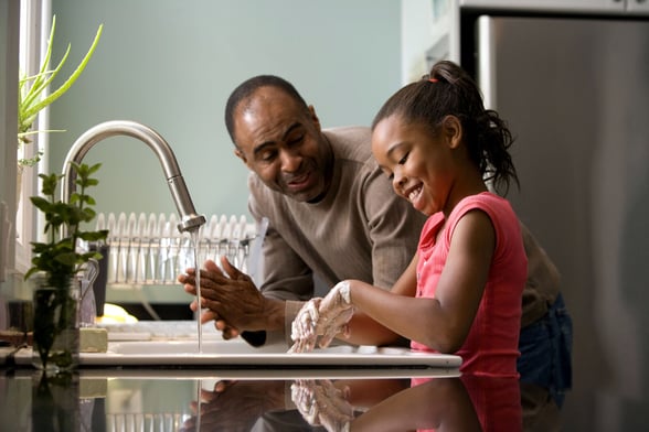 Fathers Day image of a dad telling his daughter a funny joke