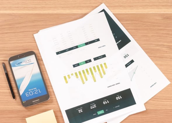 Financial Report on table with pen, phone and post its