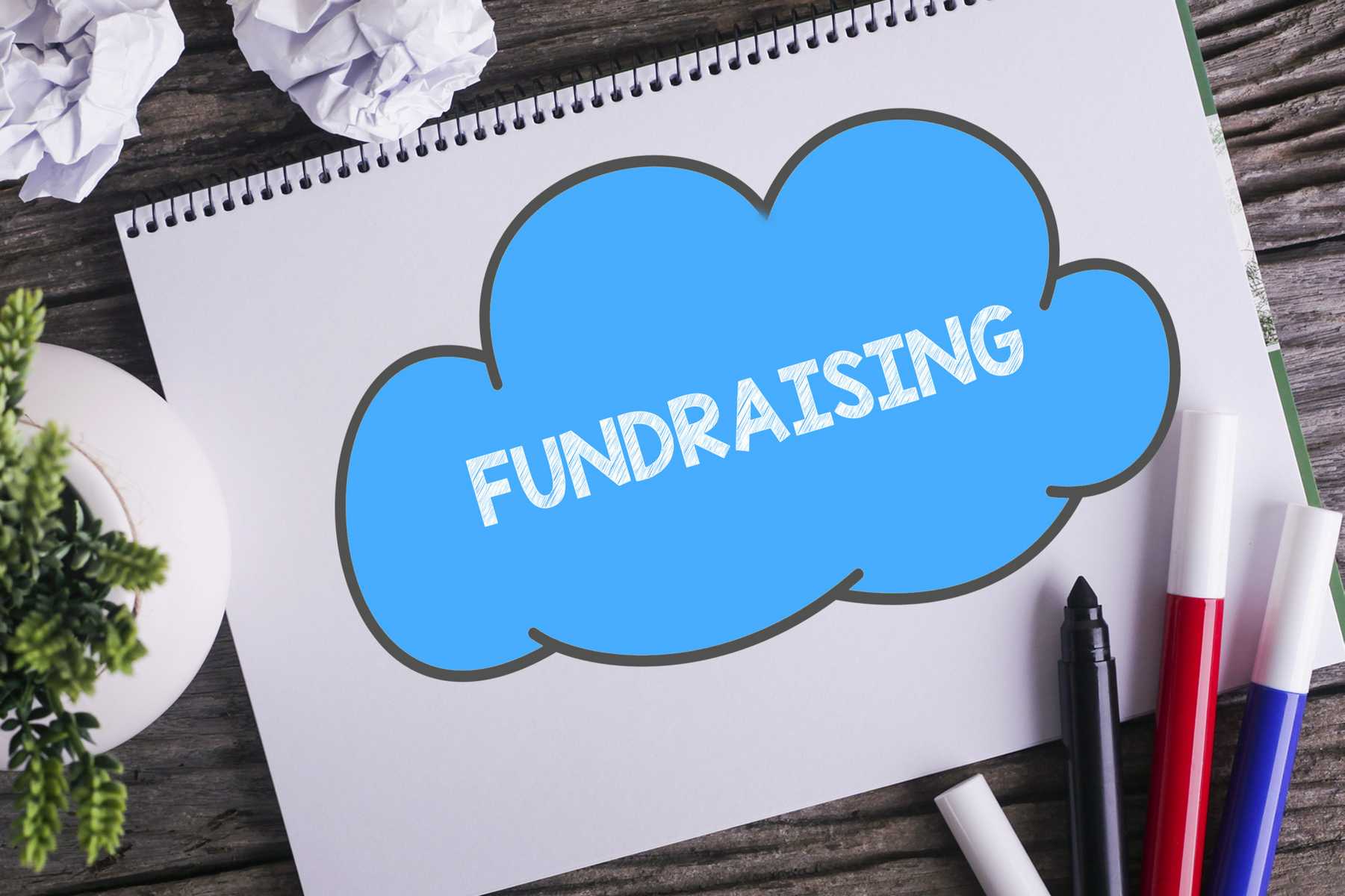 Fundraising Printed on Notepad Resting on Table