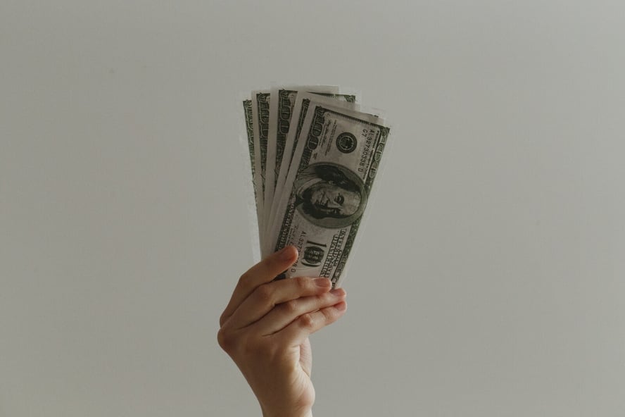 Hand holding cash from a school fundraiser