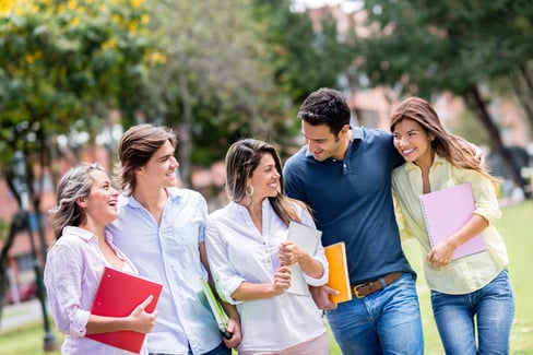 Happy group of students walking at the park