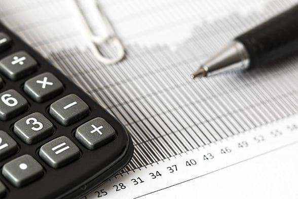 Image of a calculator, pen, and financial document