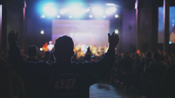 Image of a man with his hands up during worship at church