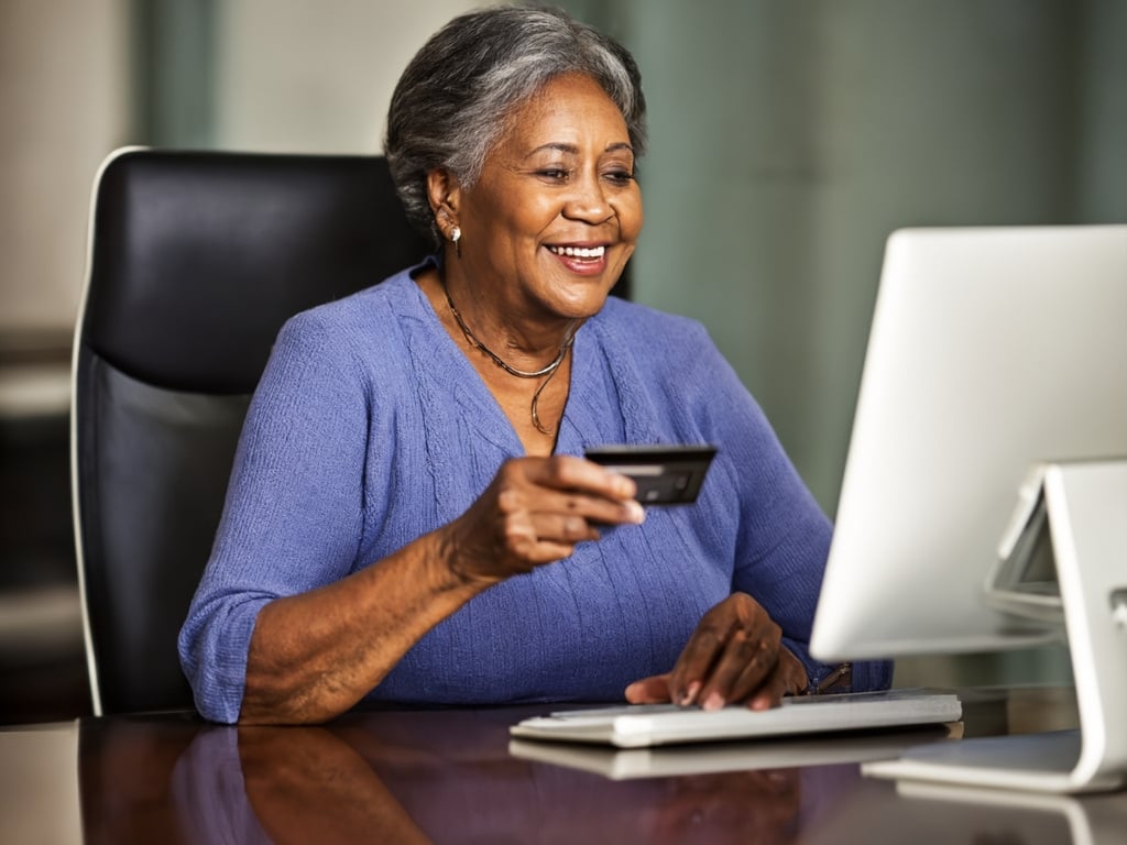 Image of an older woman holding her debite card, about to make an online donation to a nonprofit fundraiser