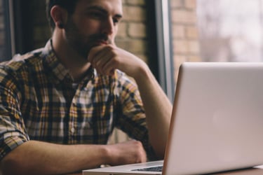 Man Setting Up Donations for a Church Website on a Laptop
