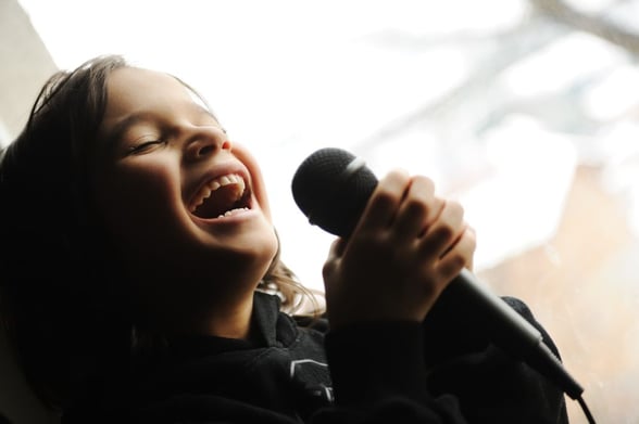 Kid singing song with microphone