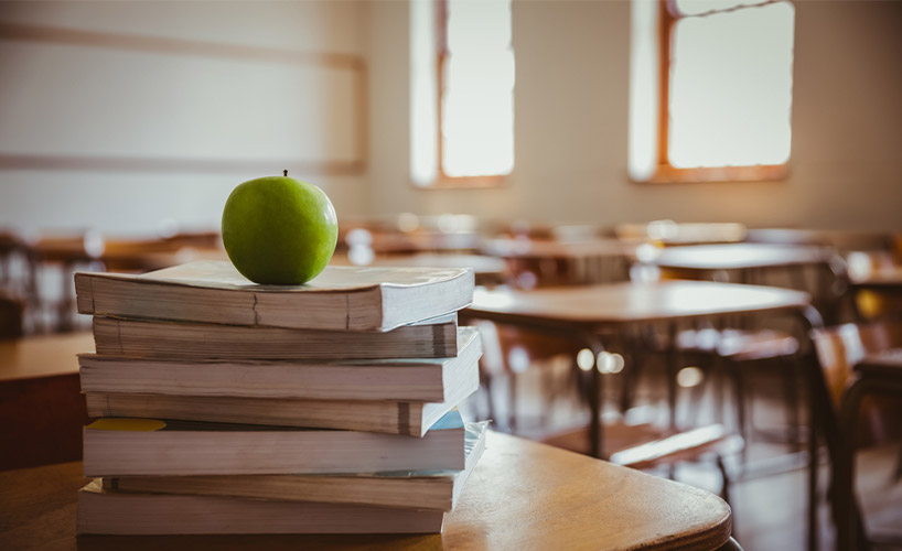Apple-on-pile-of-books-at-the-elementary-school