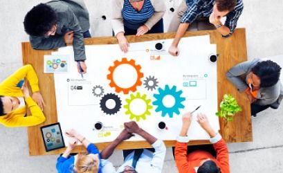 people gathered around table with gear diagram