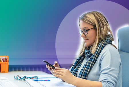 woman-looks-at-phone-at-desk