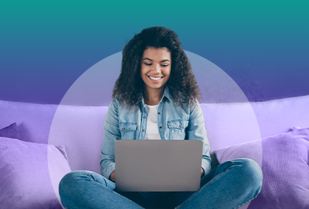 woman-sits-on-couch-with-laptop