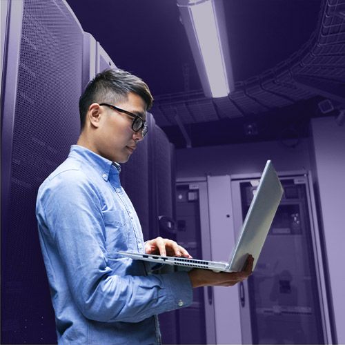 man-holding-laptop-in-server-room