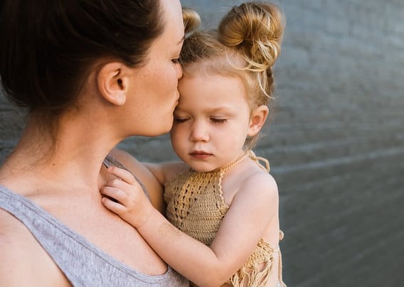 Parent holding a preschool girl