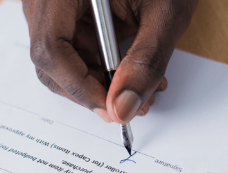 Man's hand signing document