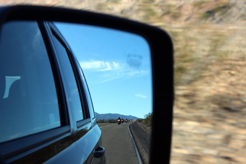 Picture of side mirror displaying a road