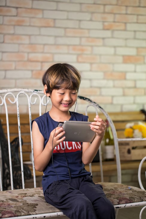 Preschool Boy Doing an Activity on a Tablet with Headphones On