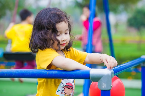 Preschooler playing outside, engaging in a spring class activity