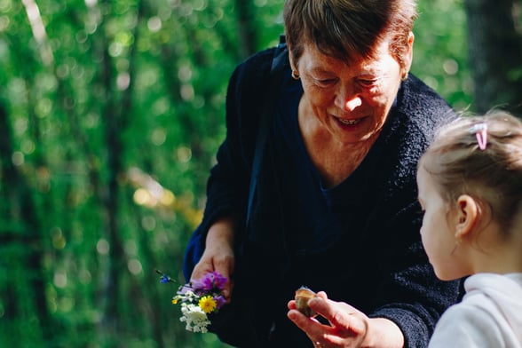 Preschool teacher and student looking at a flower together during gardening activity