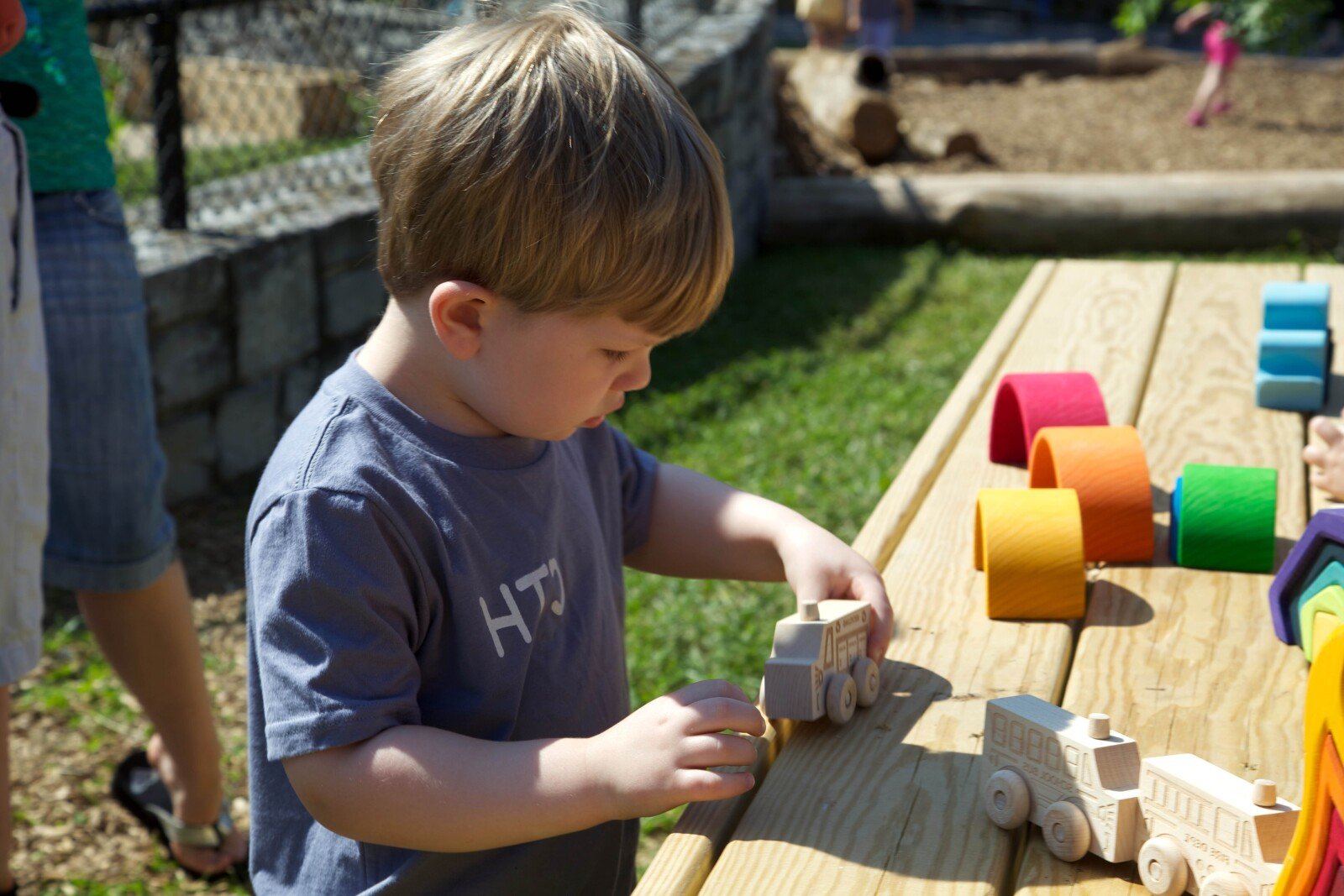 Preschooler playing outside with toy blocks