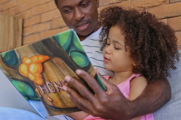 Preschooler reading a book that she got at the book fair