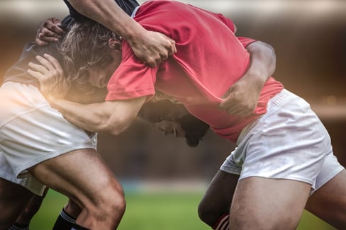 Rugby fans in arena against rugby players doing a scrum