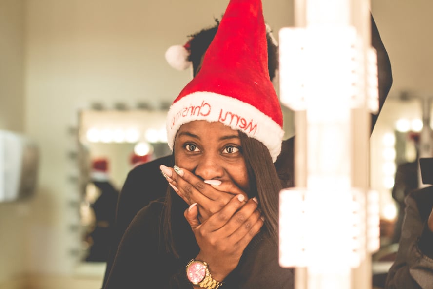 Shocked woman taking a quiz & wearing Christmas hat