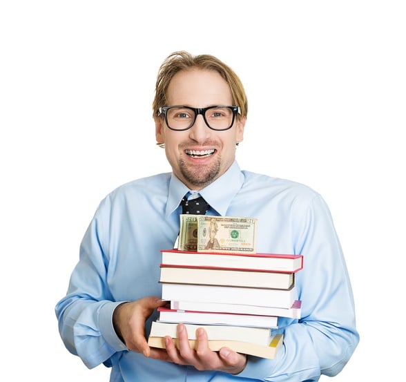 Closeup portrait of young smiling student man holding books in arms with money, cash on top, looking happy, scholarship fund or selling textbooks, isolated on white background. Education value