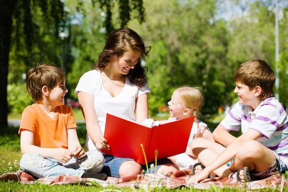 Parent with kids reading a children's bible for the children's ministry