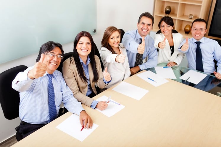 a church committee at a table giving thumbs up