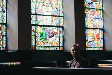 Man sitting alone in church pew