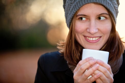 Winter woman drinking a cup of coffee ? outdoors