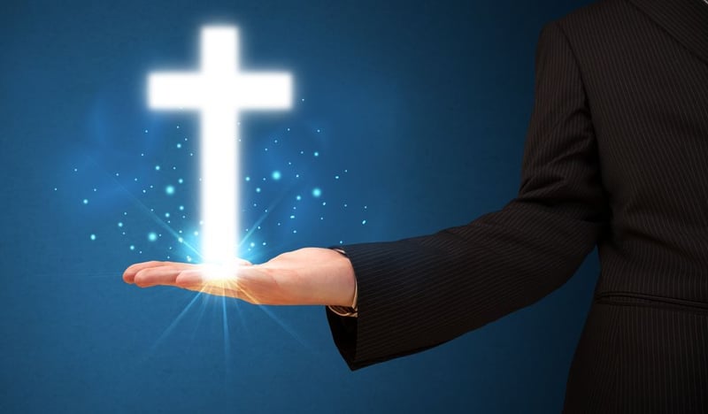 Young businessman holding a glowing cross in his hand
