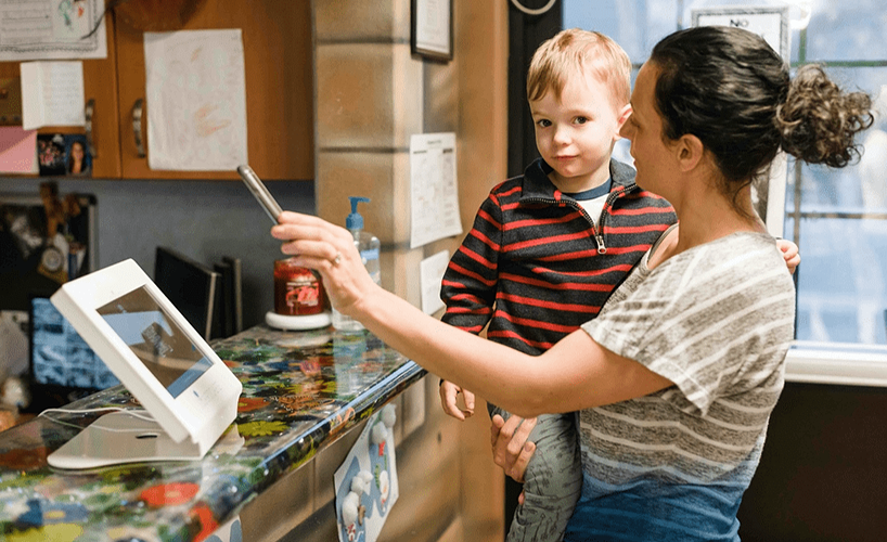 mom checking in child daycare