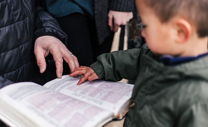 child with bible and teacher