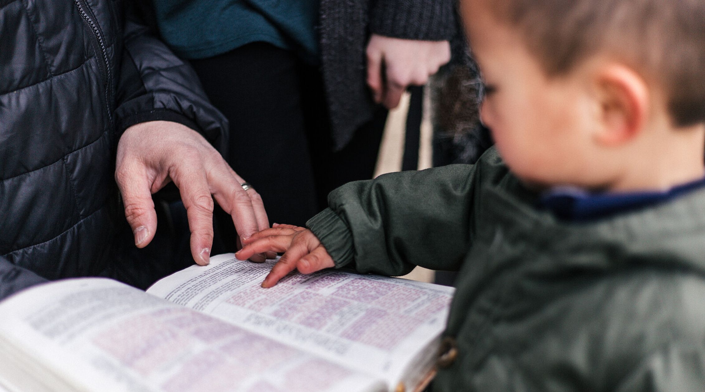 child-with-teacher-reaching-bible-one-column