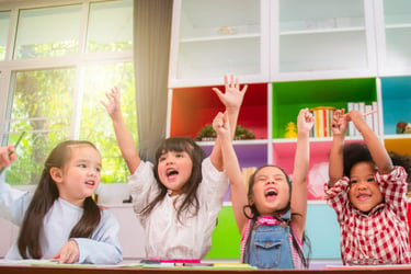 Kids raising hands happily.