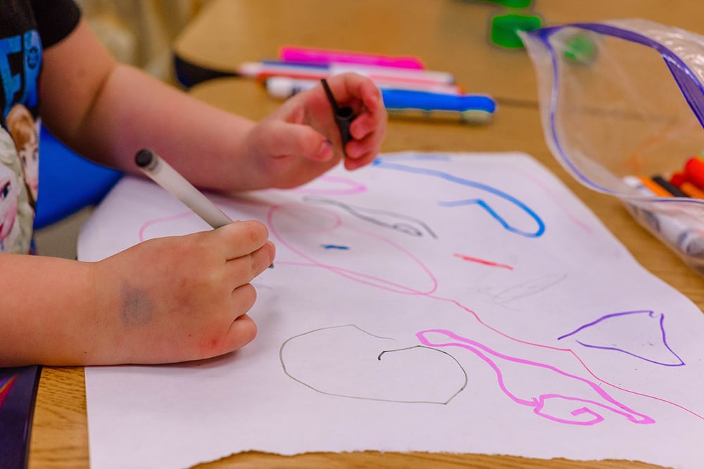 Preschooler drawing during a class activity