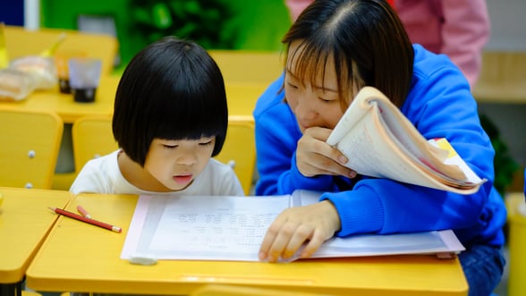 Preschool teacher and student during reading activity