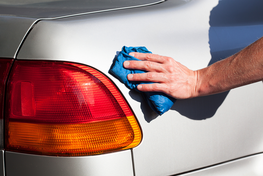 A man washing a cars body